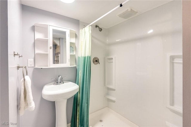 bathroom with a shower stall and a sink
