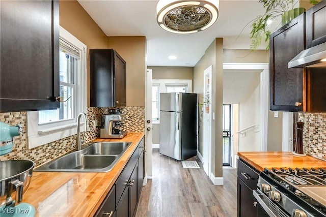 kitchen featuring butcher block counters, appliances with stainless steel finishes, a sink, and wood finished floors