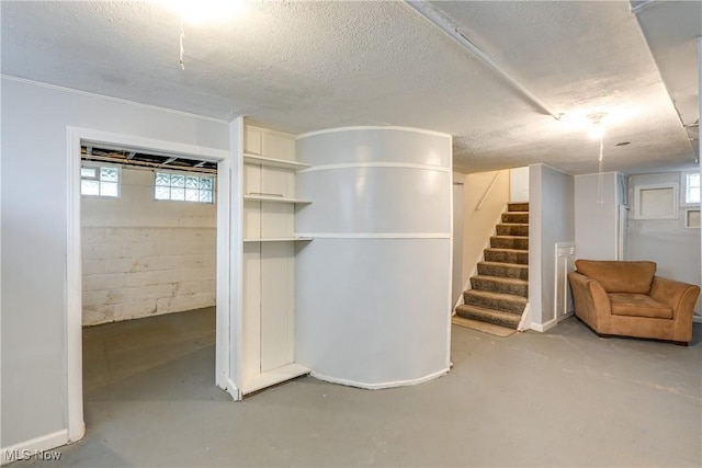 basement with stairway, plenty of natural light, and a textured ceiling