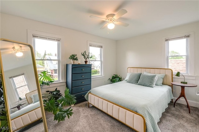 carpeted bedroom with a ceiling fan and baseboards