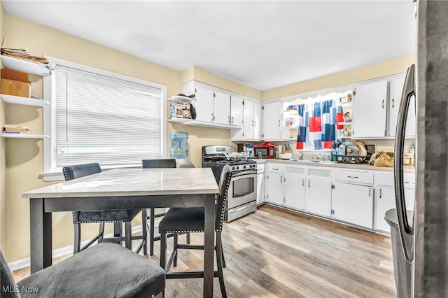 21407 Libby Rd, Maple Heights, OH 44137 - kitchen with appliances with stainless steel finishes, light wood-style flooring, white cabinetry, and light countertops