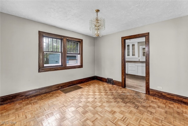 955 Dresden Rd, Cleveland Heights, OH 44112 - unfurnished room featuring baseboards, a chandelier, and a textured ceiling