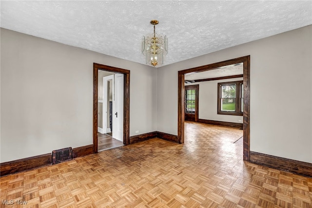 955 Dresden Rd, Cleveland Heights, OH 44112 - spare room with baseboards, a chandelier, and a textured ceiling
