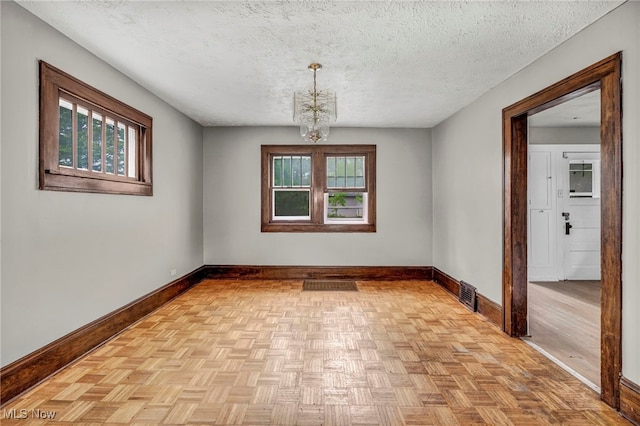 955 Dresden Rd, Cleveland Heights, OH 44112 - spare room with baseboards, a chandelier, and a textured ceiling
