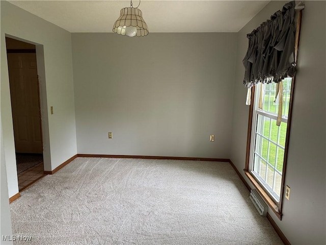 empty room with carpet floors, healthy amount of natural light, and baseboards