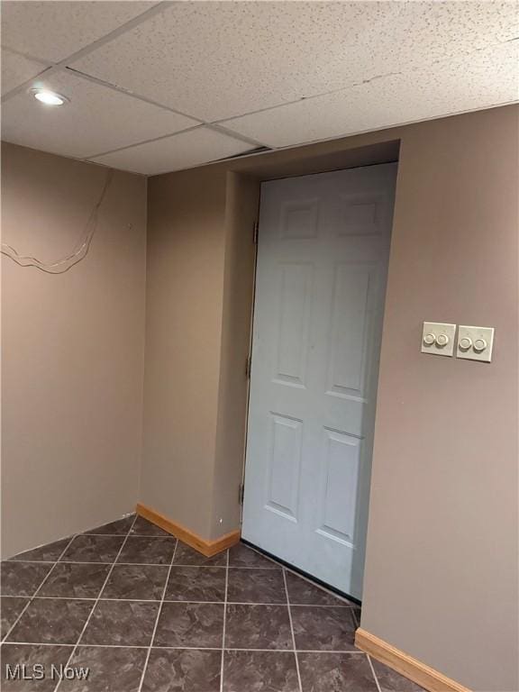 unfurnished room featuring baseboards, dark tile patterned flooring, and recessed lighting