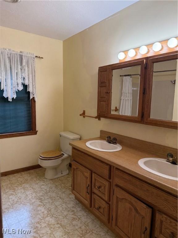 bathroom featuring toilet, double vanity, tile patterned floors, and a shower with curtain