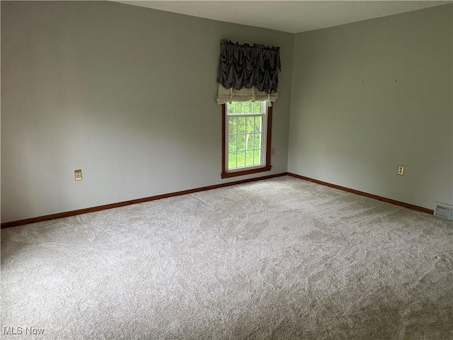 unfurnished room with carpet flooring and baseboards