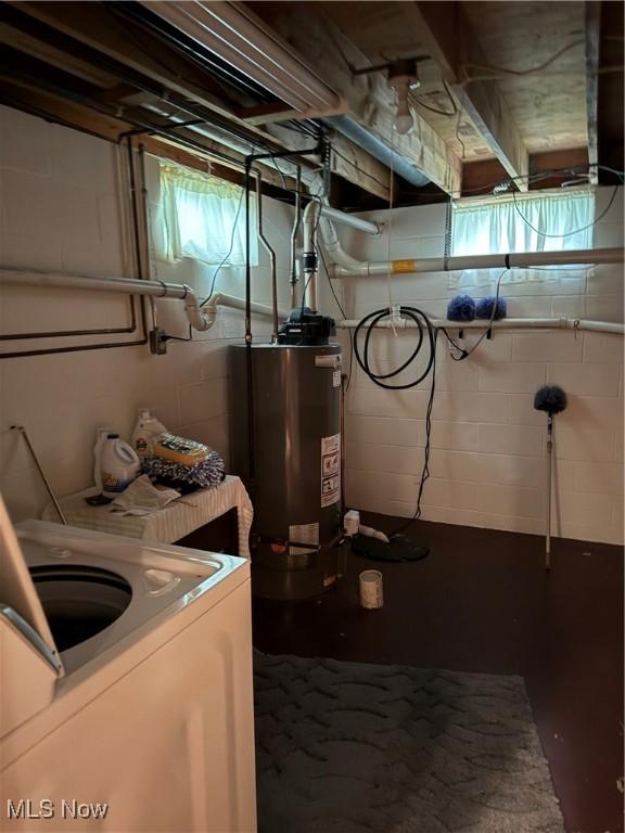 unfinished below grade area with water heater and washer / clothes dryer