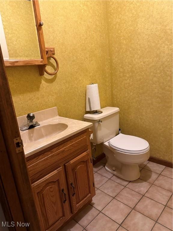 bathroom featuring tile patterned flooring, toilet, and vanity