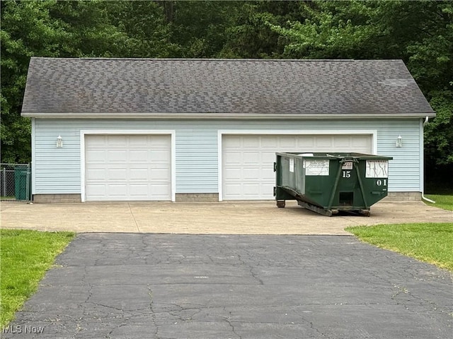 detached garage featuring fence