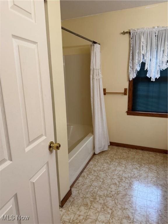 bathroom with tile patterned floors, shower / bath combo, and baseboards