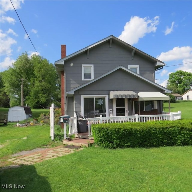 1093 Alliance Rd NW, Minerva, OH 44657 - rear view of house with a storage unit, a chimney, a lawn, and an outbuilding