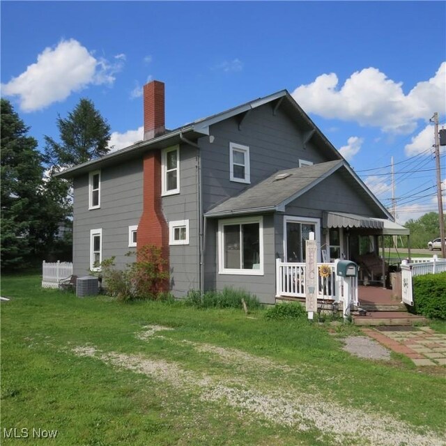 1093 Alliance Rd NW, Minerva, OH 44657 - back of house featuring a chimney, a yard, and central AC