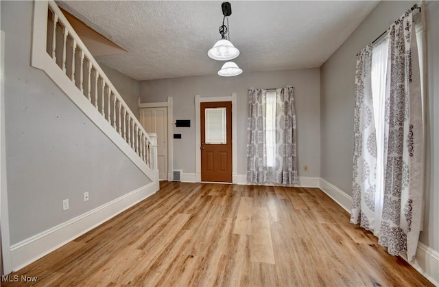 601 Short St, Dover, OH 44622 - foyer with stairway, wood finished floors, baseboards, and a textured ceiling