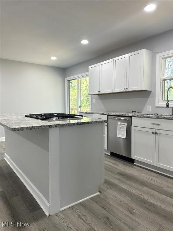 4378 Victoria Ter SE, Warren, OH 44484 - kitchen featuring stainless steel appliances, recessed lighting, dark wood finished floors, a center island, and light stone counters