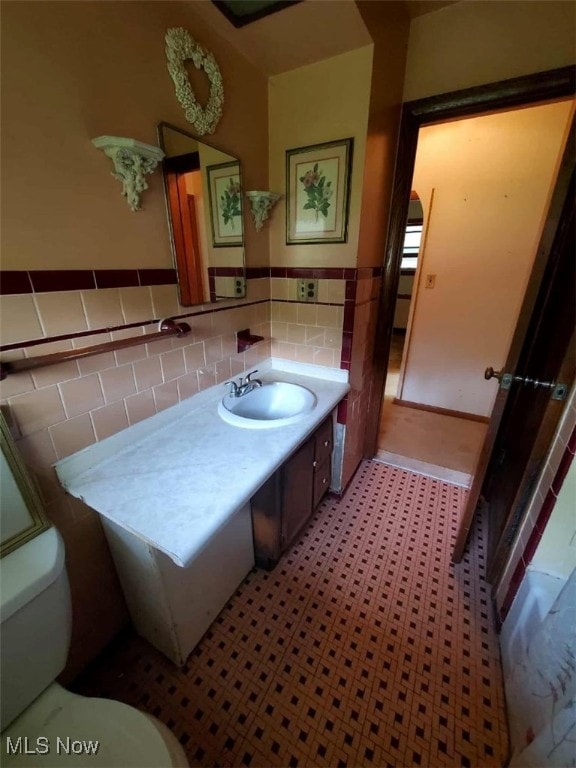 7417 Broadview Rd, Seven Hills, OH 44131 - bathroom with toilet, tile walls, vanity, and a wainscoted wall