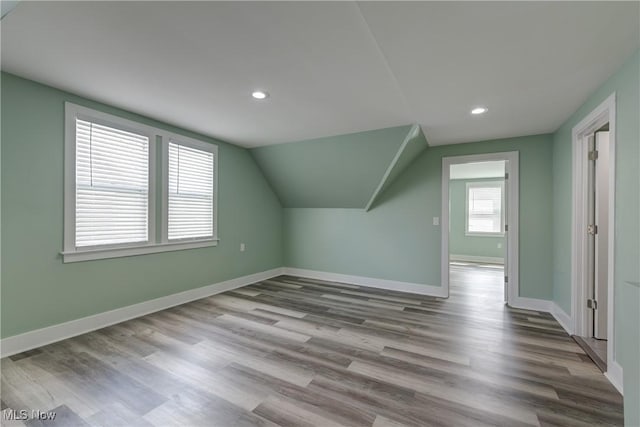 additional living space featuring baseboards, recessed lighting, wood finished floors, and vaulted ceiling
