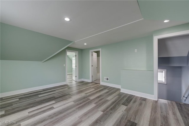 additional living space with wood finished floors, recessed lighting, and baseboards