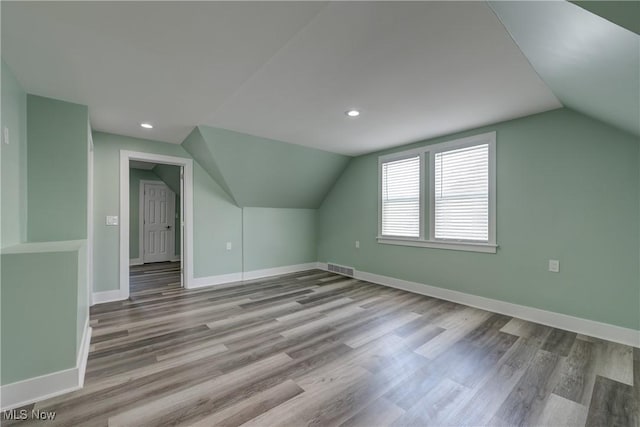 bonus room with vaulted ceiling, baseboards, wood finished floors, and recessed lighting