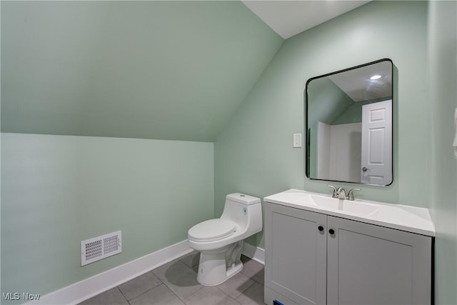 bathroom with lofted ceiling, baseboards, vanity, toilet, and tile patterned flooring