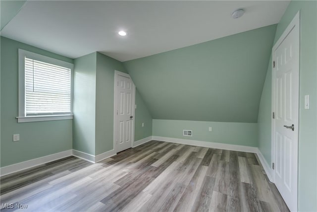 bonus room featuring lofted ceiling, wood finished floors, baseboards, and recessed lighting