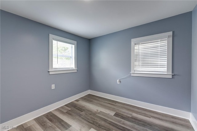 empty room featuring baseboards and wood finished floors