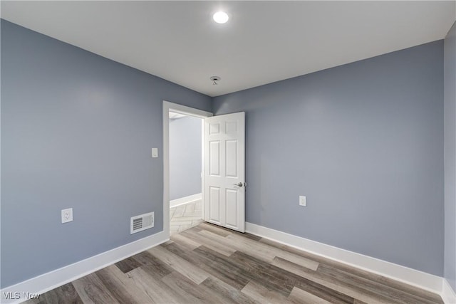 empty room featuring baseboards, wood finished floors, and recessed lighting
