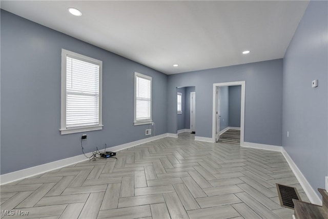empty room featuring baseboards and recessed lighting