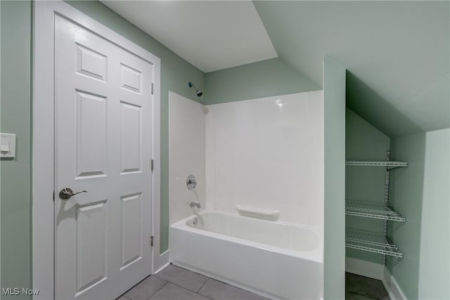 bathroom with tile patterned flooring, baseboards, lofted ceiling, and shower / bath combination