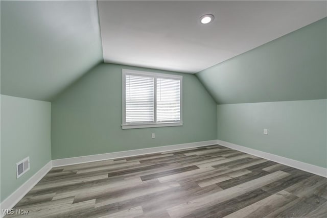 bonus room featuring wood finished floors, vaulted ceiling, baseboards, and recessed lighting