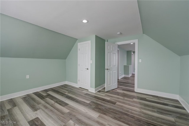 bonus room with lofted ceiling, baseboards, wood finished floors, and recessed lighting