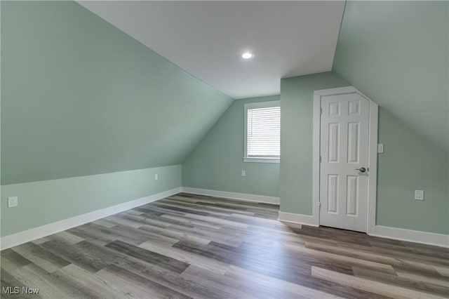 bonus room with lofted ceiling, wood finished floors, baseboards, and recessed lighting