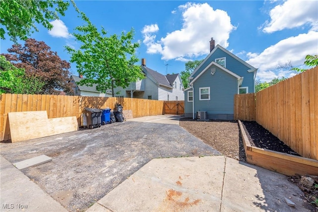 back of house with a patio, central AC unit, a fenced backyard, and a chimney