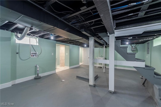 finished below grade area with baseboards, stairs, and gas meter