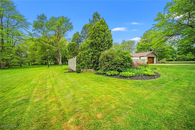 view of grassy yard featuring a garage and driveway