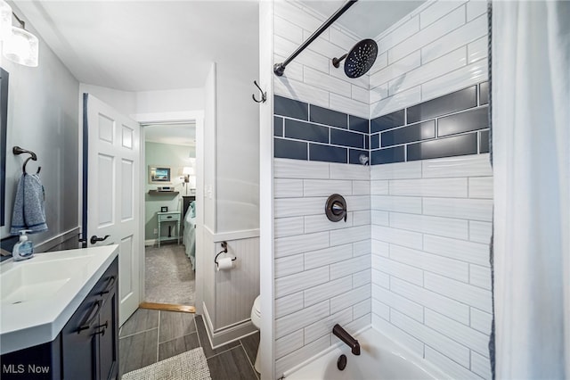 bathroom featuring toilet, vanity, tub / shower combination, and wood tiled floors