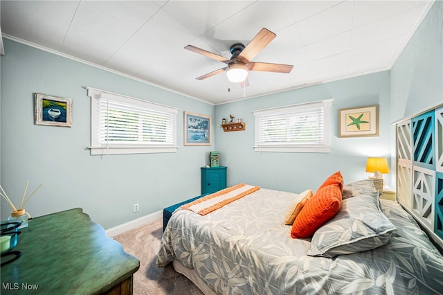 bedroom with multiple windows, carpet flooring, ornamental molding, baseboards, and ceiling fan