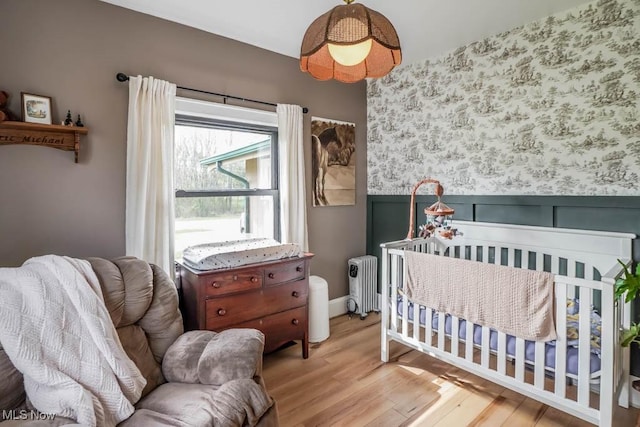 6319 Columbus Rd NE, Louisville, OH 44641 - bedroom featuring radiator, wood finished floors, and wainscoting