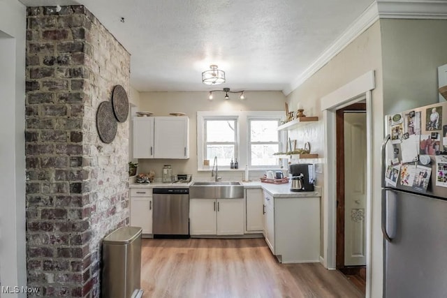 6319 Columbus Rd NE, Louisville, OH 44641 - kitchen with stainless steel appliances, a sink, light wood-style flooring, white cabinets, and a textured ceiling