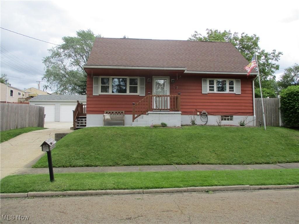 1445 Climax Ave, Akron, OH 44310 - view of front of house with a garage, a shingled roof, and an outbuilding