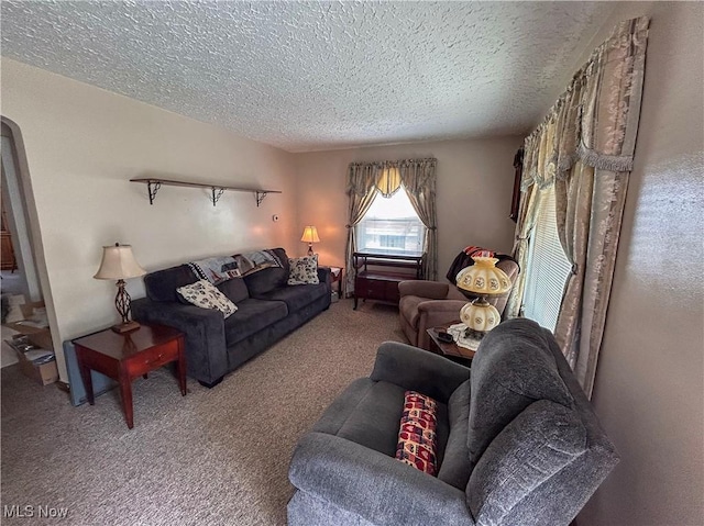 carpeted living room featuring a textured ceiling and arched walkways