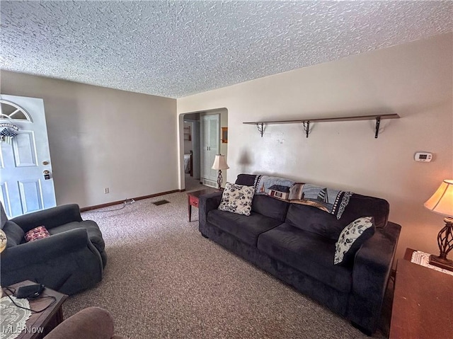 living room with a textured ceiling, carpet floors, and baseboards