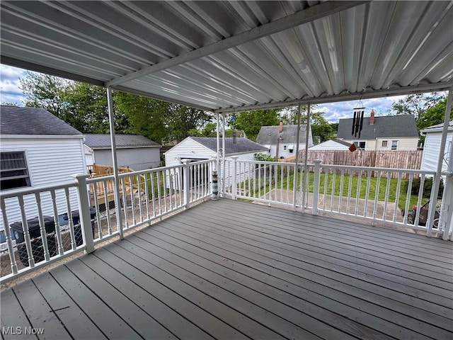 deck with an outdoor structure, a residential view, and fence