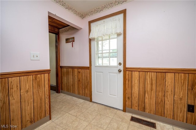 390 E Clark St, East Palestine, OH 44413 - doorway to outside with wainscoting, wood walls, and light flooring