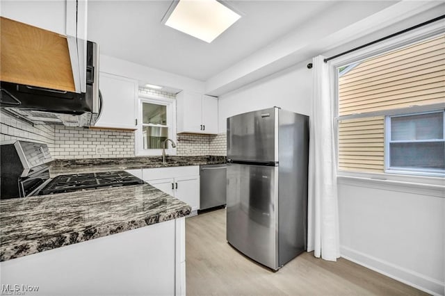 1212 Eastwood Ave, Mayfield Heights, OH 44124 - kitchen with stainless steel appliances, light wood-style flooring, a sink, and tasteful backsplash
