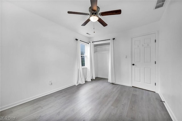 1212 Eastwood Ave, Mayfield Heights, OH 44124 - unfurnished bedroom featuring wood finished floors, baseboards, a ceiling fan, and a closet