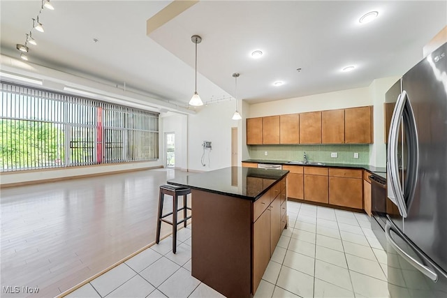 2030 Euclid Ave Unit 201, Cleveland, OH 44115 - kitchen featuring freestanding refrigerator, decorative backsplash, a kitchen island, and light tile patterned floors