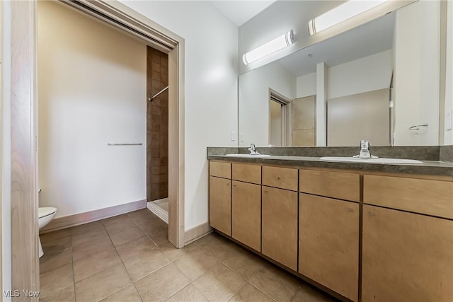 2030 Euclid Ave Unit 201, Cleveland, OH 44115 - full bath with toilet, baseboards, tile patterned flooring, double vanity, and tiled shower