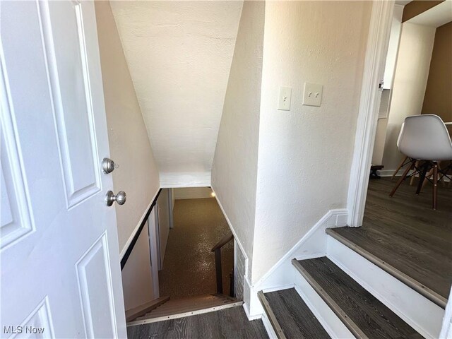 19708 Sunset Dr, Warrensville Heights, OH 44122 - staircase with wood finished floors, a textured wall, and baseboards